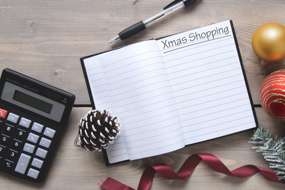 Budgeting at Christmas, with shopping list, pen and calculator