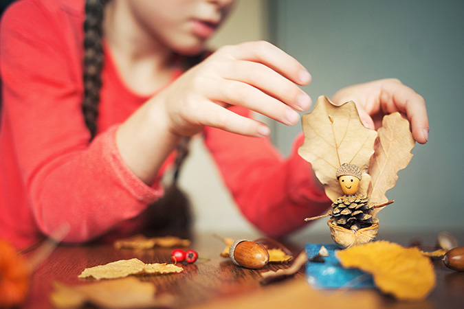 A girl doing some craft with outdoors material