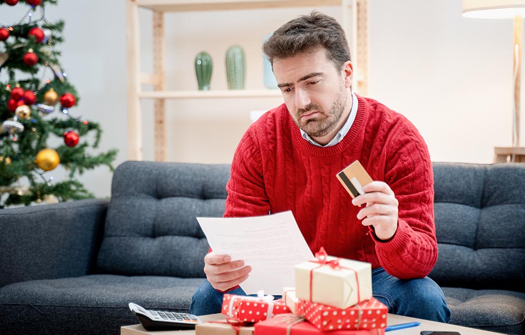 A man working through his credit card statmen and Christmas debt