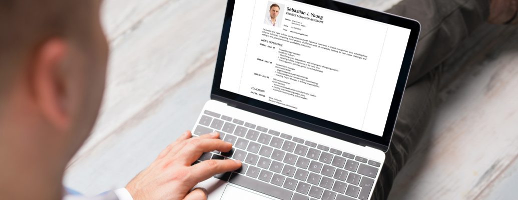 Man writing a CV on a laptop