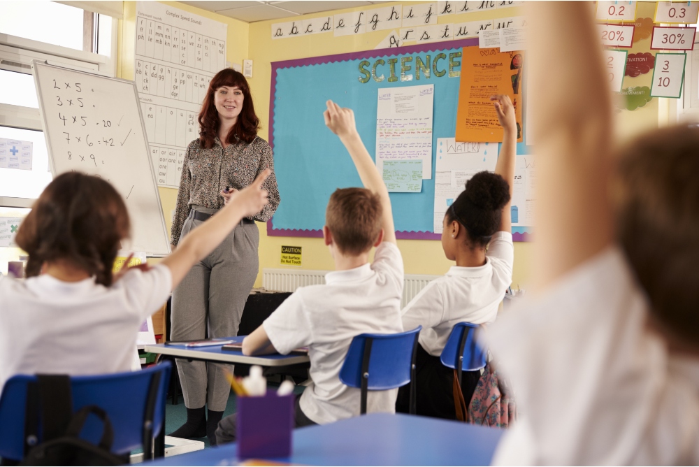 Kids raising hands in a primary school class