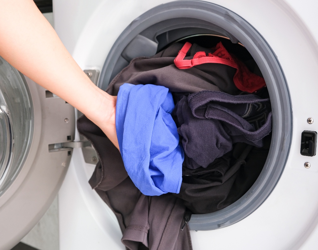 Clothes being put in a washing machine