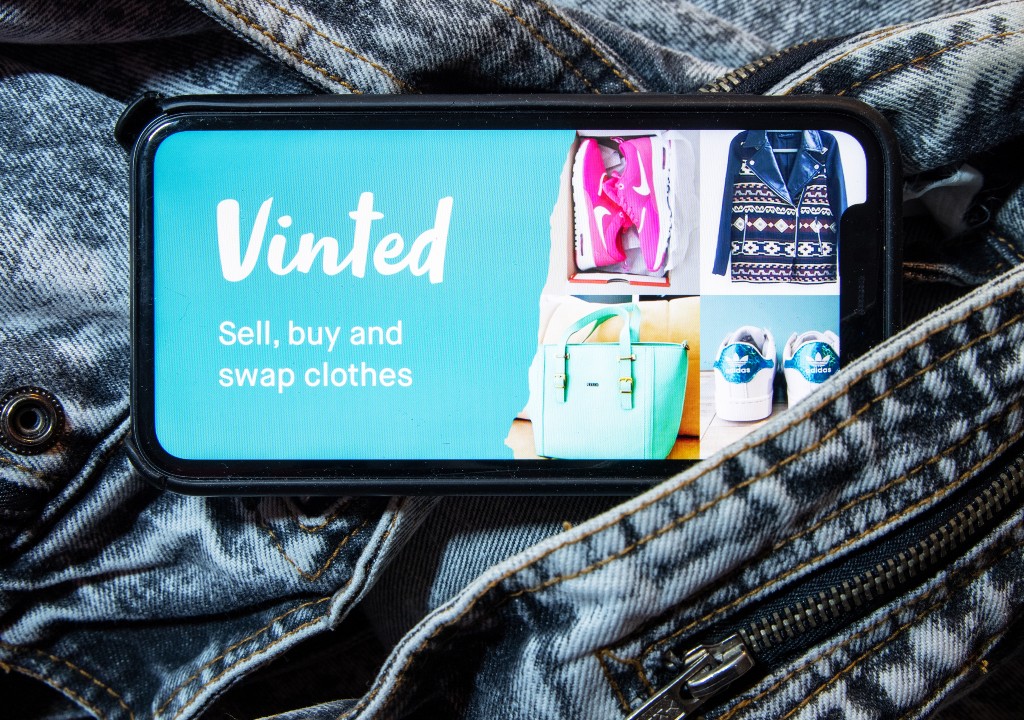 Vinted app showing on a phone screen wiith vintage jeans in the background