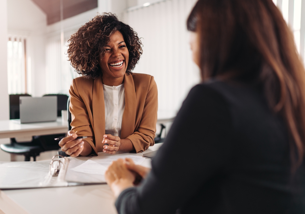 Lady giving advice to another lady in an office setting