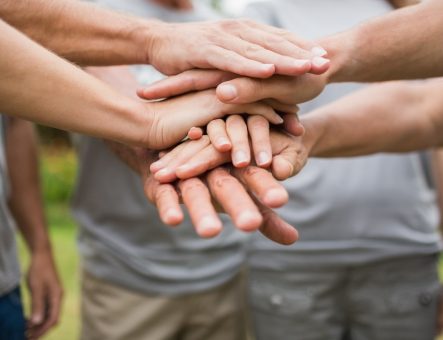 Group of hands joining in centre of the photo