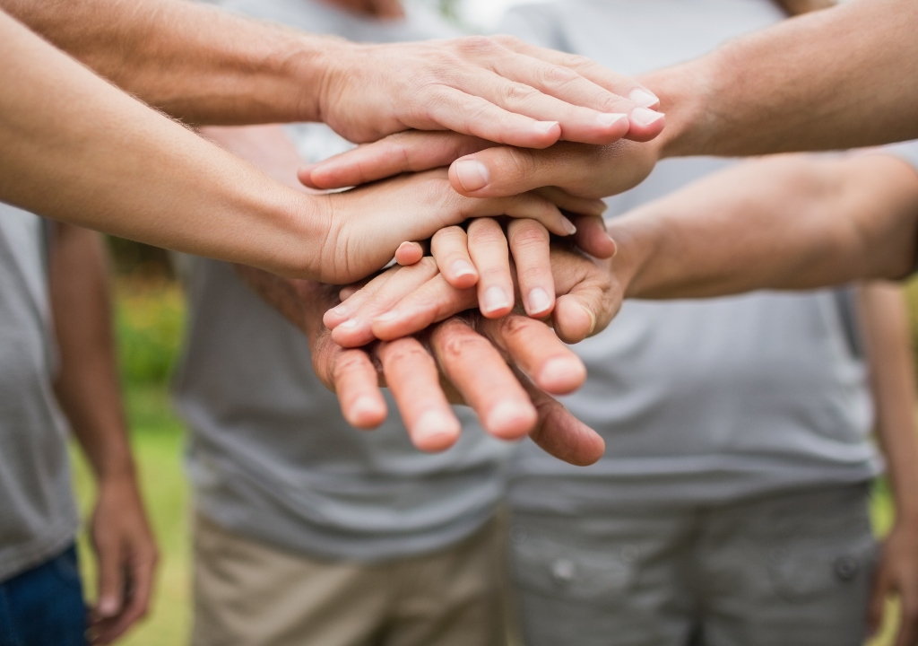 Group of hands joining in centre of the photo