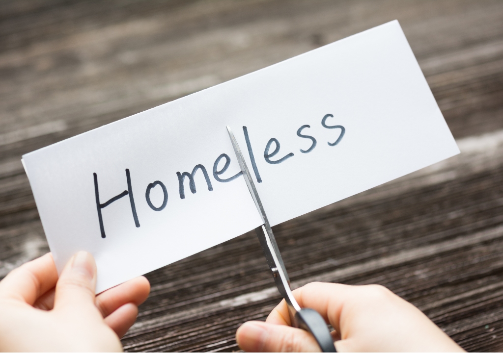 The word homeless on a piece of paper being cut in half